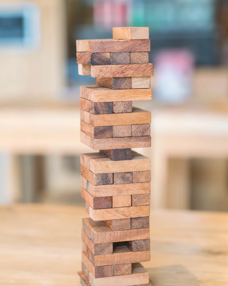 Jenga toren met verschillende stukken eruit, wat symbool staat voor een mogelijke crisis