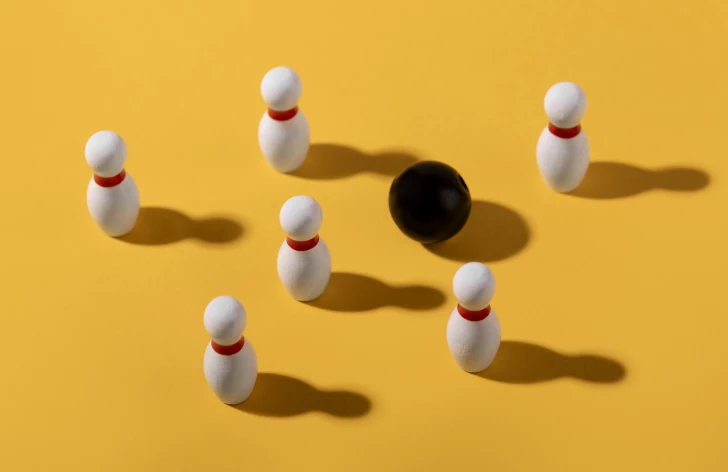 Bowling pionnen waar een zwarte bowlingbal doorheen navigeert