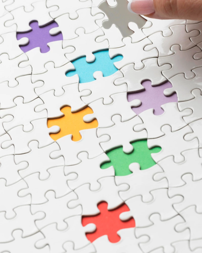Een puzzel met meerdere ontbrekende puzzelstukjes, die allen verschillend zijn in kleur als weergaven van verschillende type problemen.