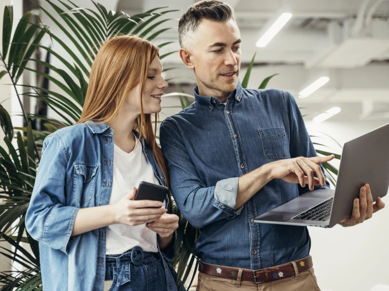 Man en vrouw kijken samen naar een laptop waar de te nemen stappen en uitkomsten van de Lean Scans op staan weergegeven
