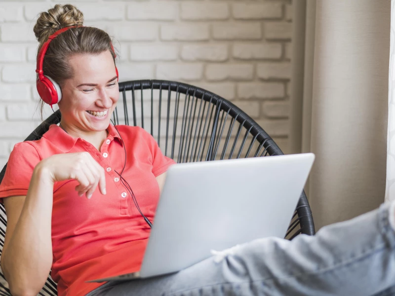 Vrouw met koptelefoon op volgt online lean six sigma cursus en lacht daarbij