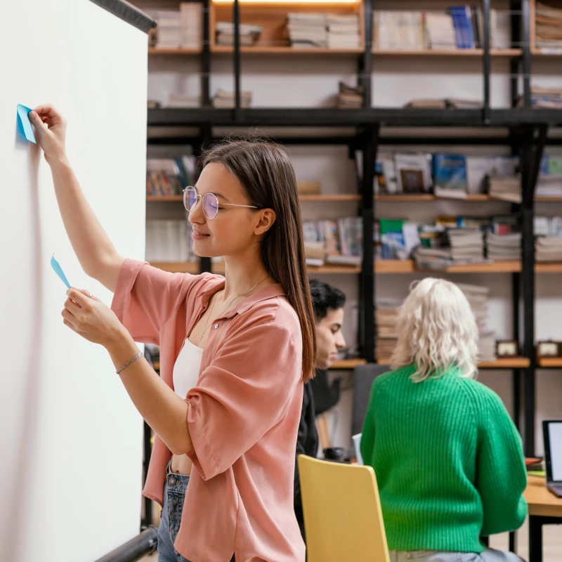 Mensen die samen post-its plakken op een bord, om te laten zien dat iedere organisatie baat heeft met continu verbeteren