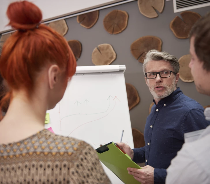 Groep mensen die resultaten analyseren op een flipover