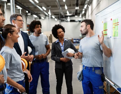 Werknemer presenteert de status van de operatie naar een groep collega's tijdens een dagstart